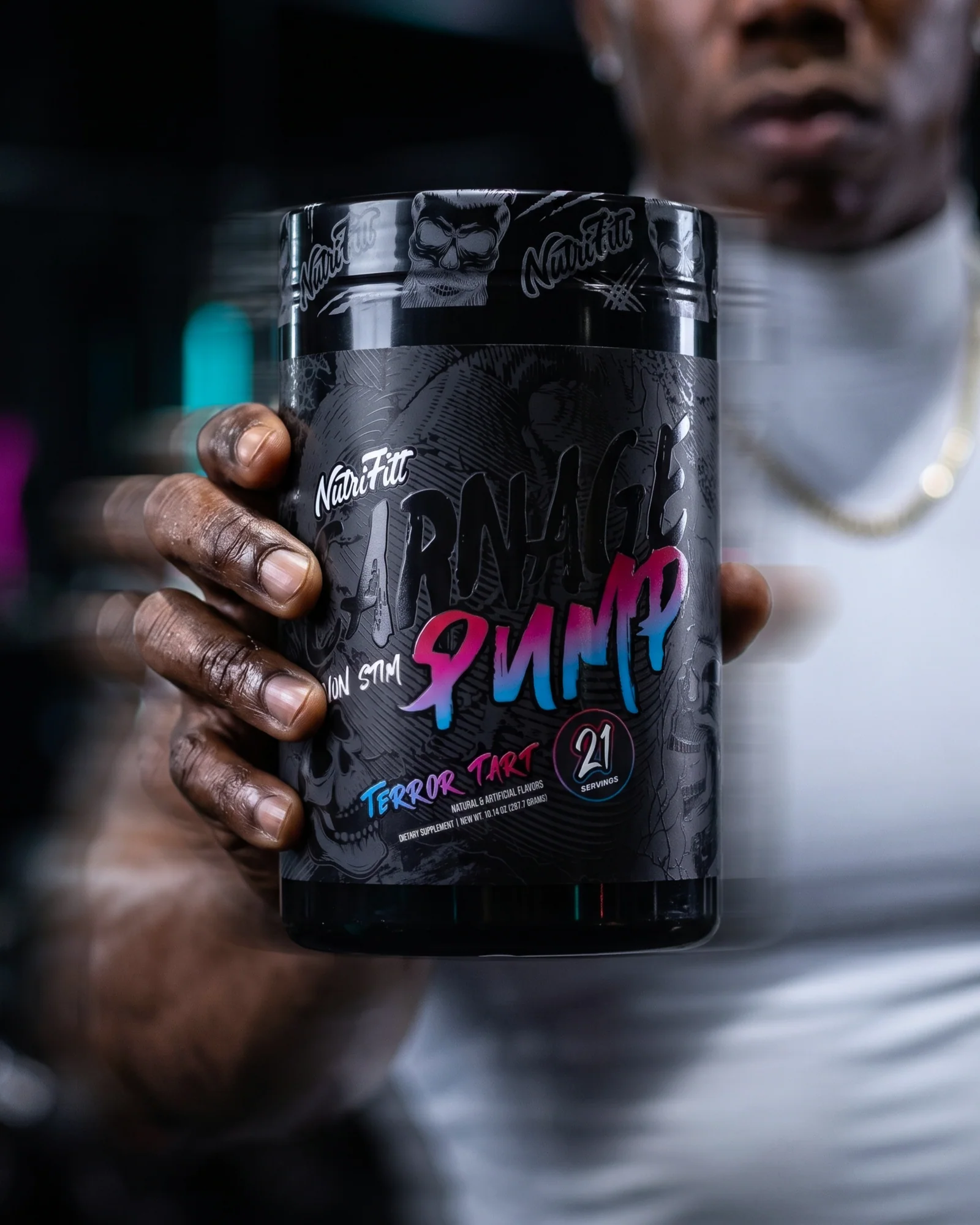 Close-up of a hand presenting NutriFitt Carnage Pump Terror Tart with an athlete blurred behind it.