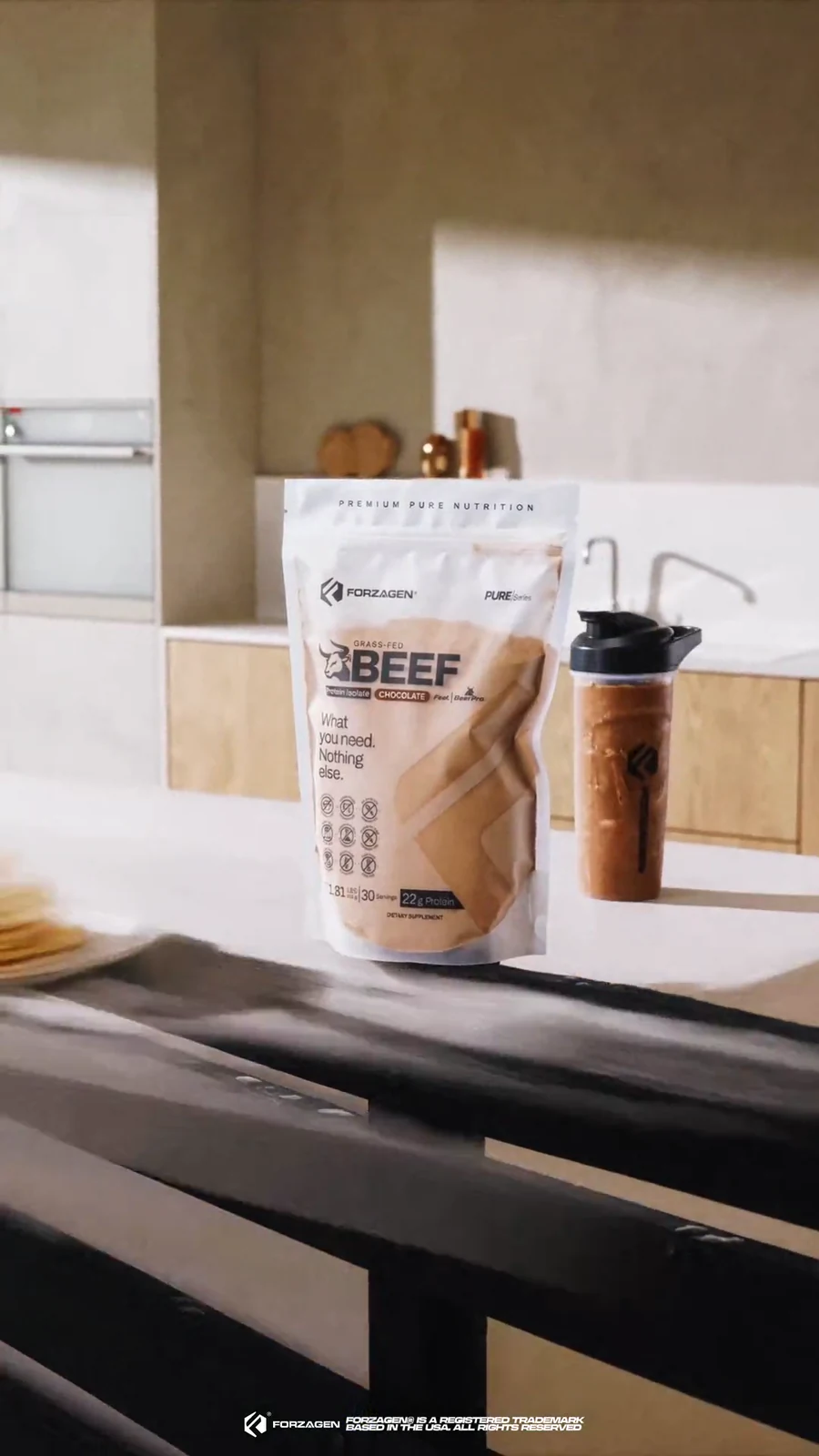 Two Pure Beef bags and a chocolate shaker stand together in a minimalist kitchen.