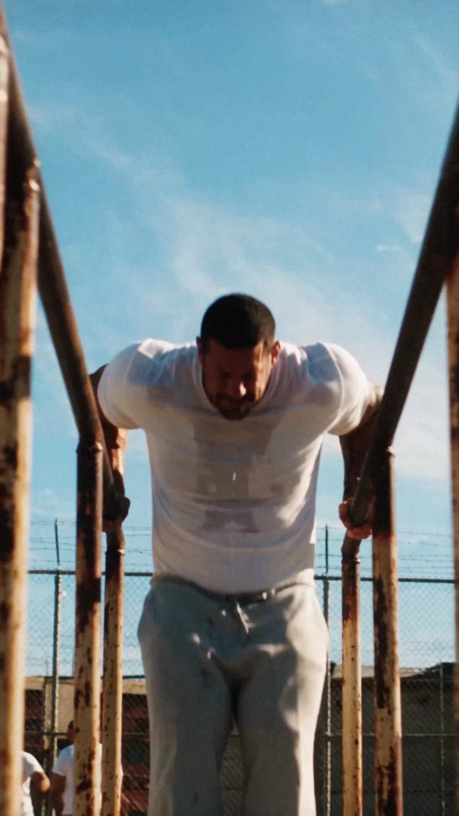 An athlete performs a dip beneath the blue sky.