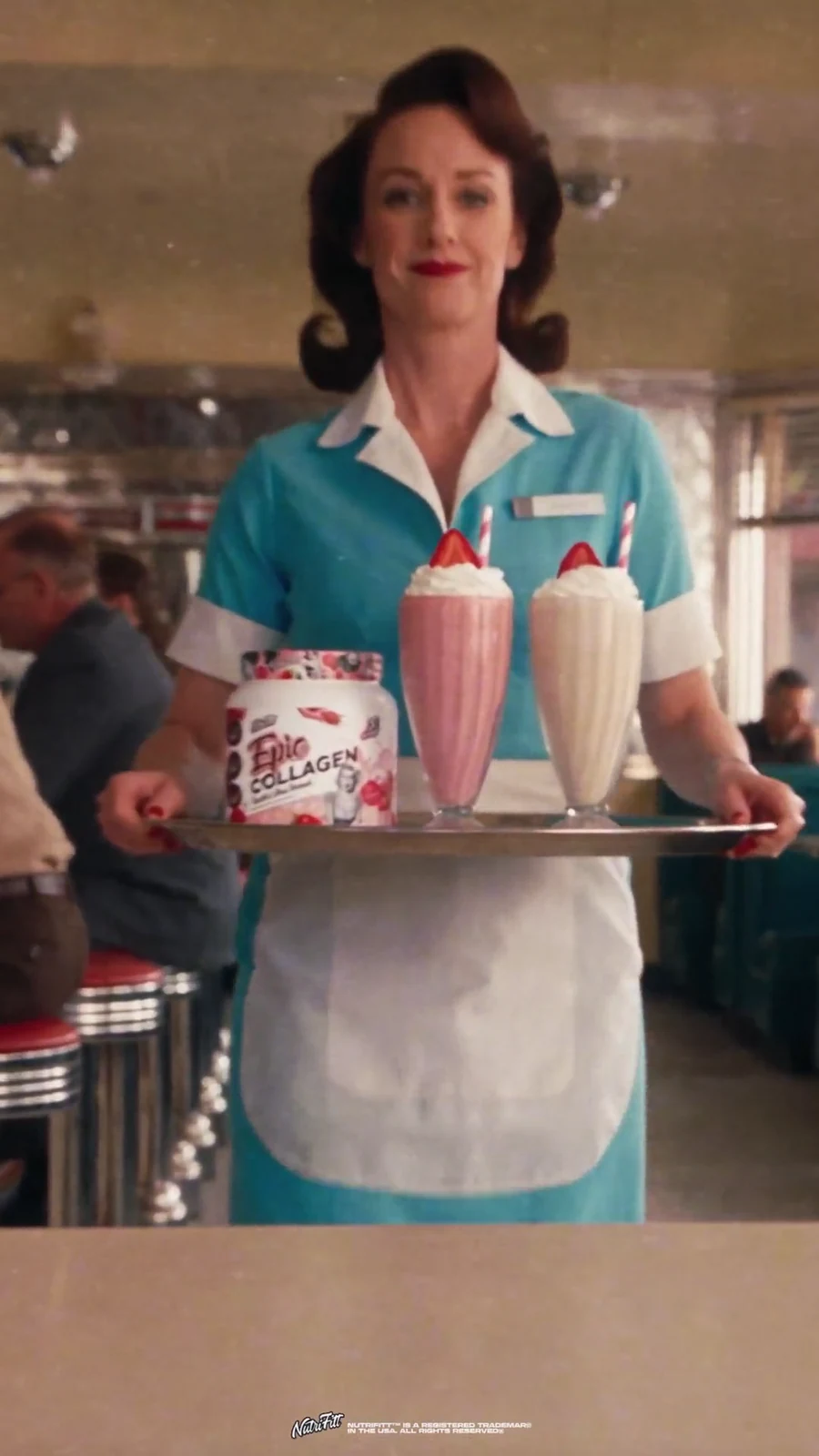 Waitress presents two Epic Collagen tubs with pink and vanilla milkshakes on a tray.