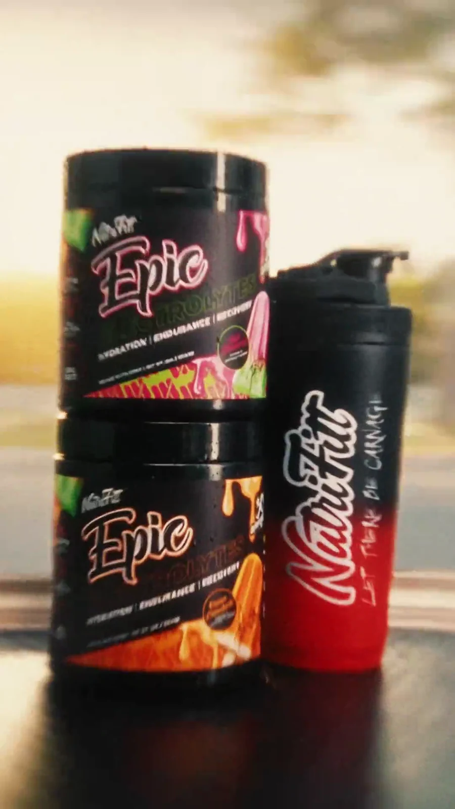 Two black Epic hydration tubs and a red branded shaker staged against warm sunset light.
