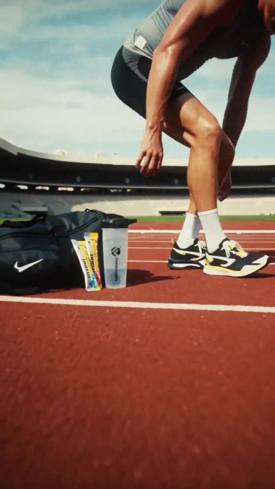 Runner adjusts a shoe beside Hydragen sachets and a Forzagen shaker on the track.