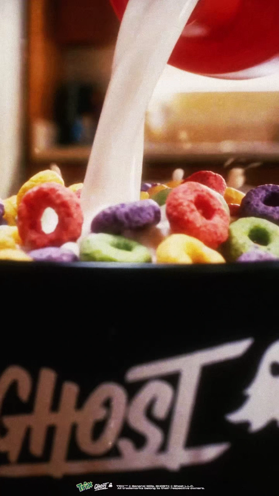 Milk pours into colorful Trix cereal in a black Ghost bowl.