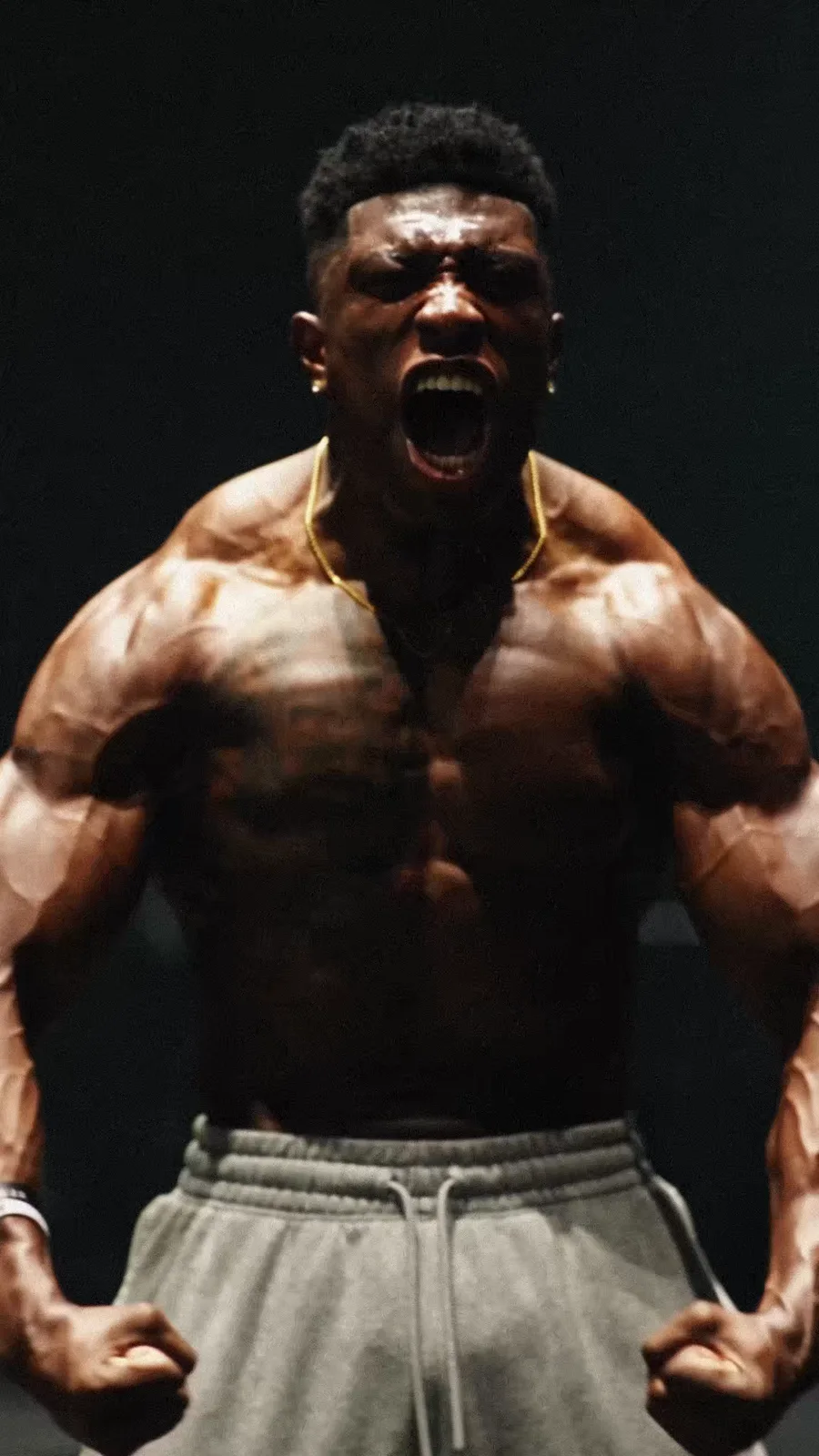 The athlete poses under hard overhead light after the training sequence.