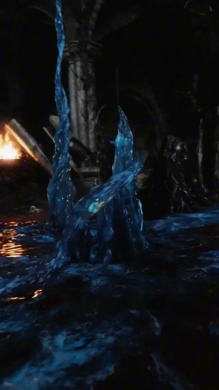 Electric-blue liquid forms a guardian-like figure inside the ruined gothic chamber.