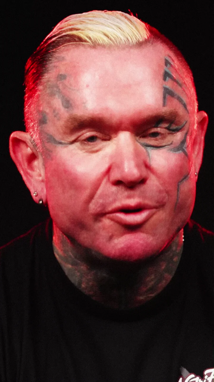 Lee Priest speaking to camera in a black NutriFitt shirt.