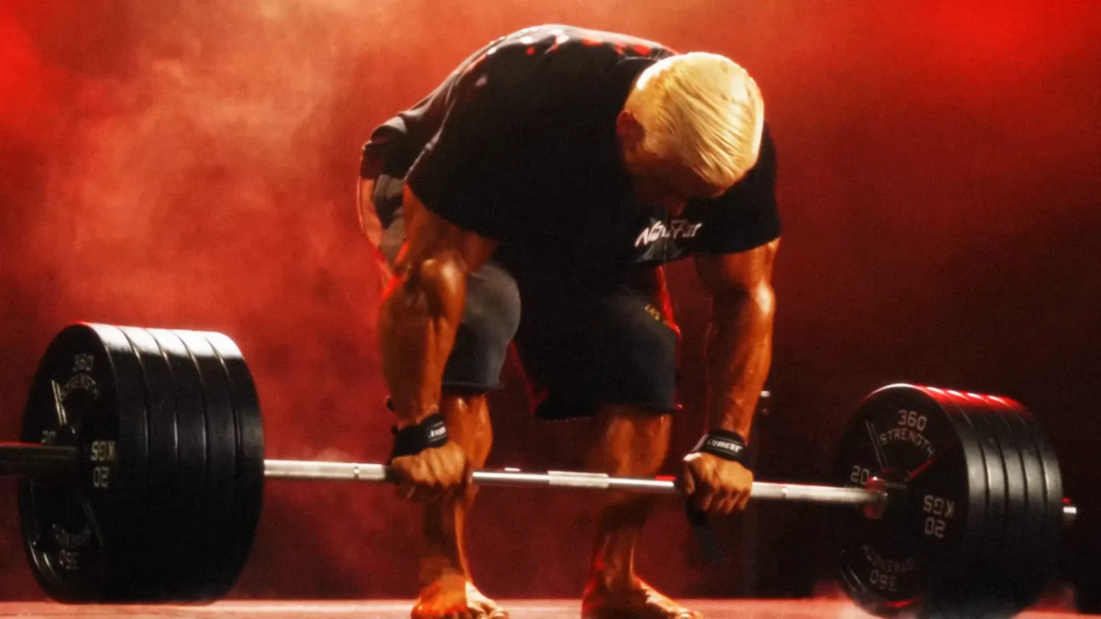 Lee Priest pulls a heavy deadlift through red smoke.