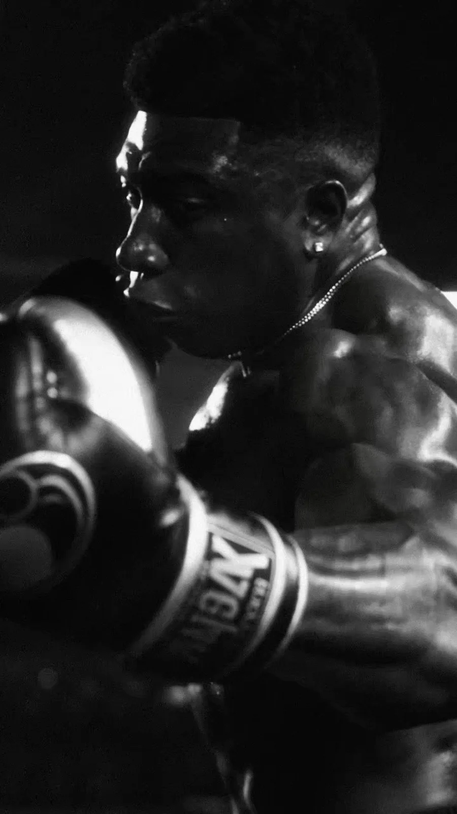 TheOneCay works the heavy bag in a high-contrast monochrome boxing close-up.