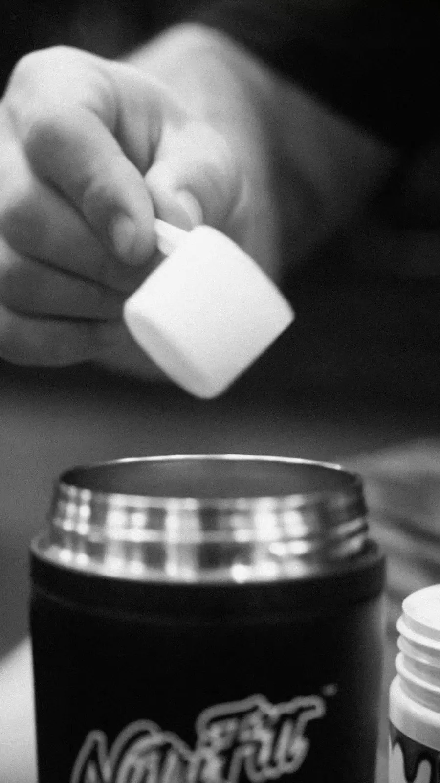 A scoop of powder goes into a steel NutriFitt shaker.