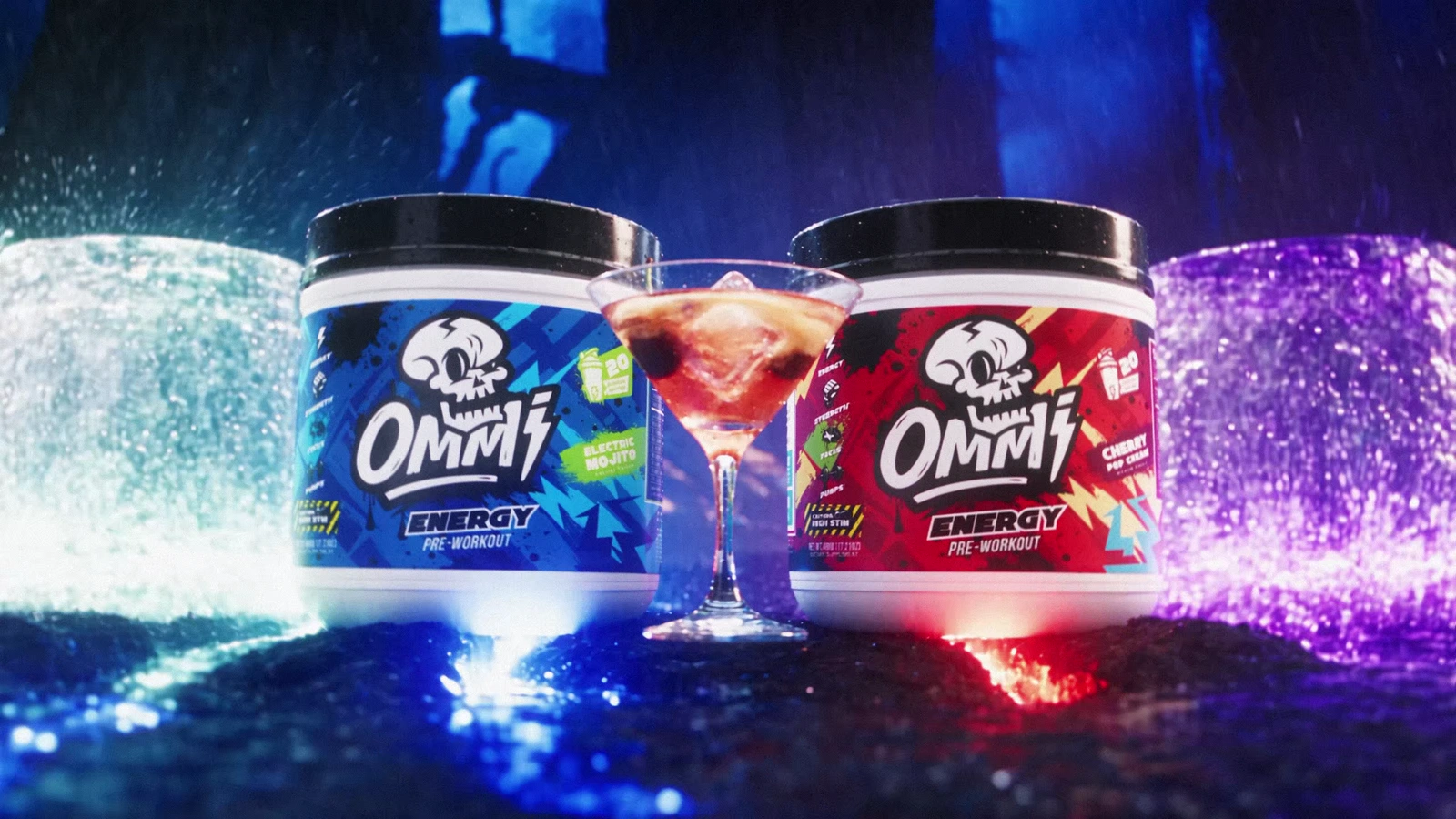 Blue and red Ommi Energy pre-workout tubs flank a cherry cocktail in a glowing blue-and-magenta forest set.