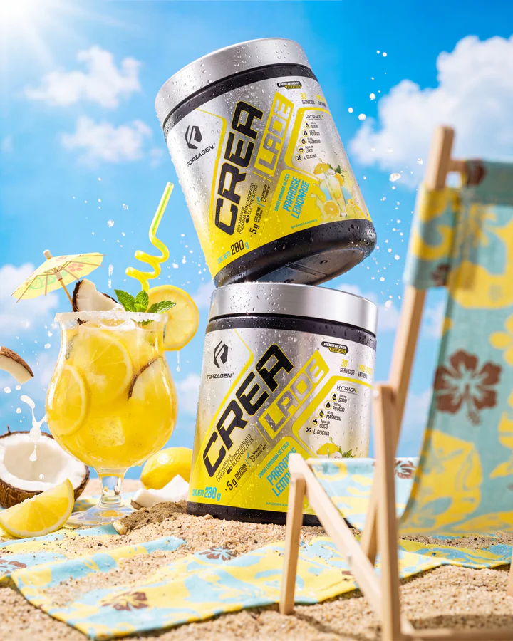 Pink, blue and yellow CREA LADE tubs stack on a beach set beside matching iced flavor drinks.