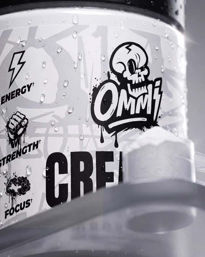 Macro of the Ommi Creatine label highlights energy, strength and focus icons beside the white tub.