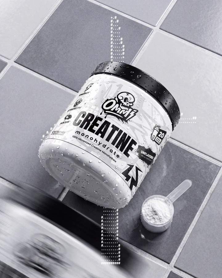 Ommi Creatine tub and clear measuring scoop sit on a technical black-and-white grid.