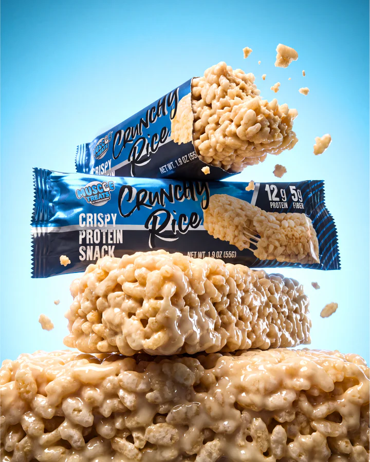 Rice-crisp pieces and grains burst above stacked Crunchy Rice wrappers and a large snack-bar macro.