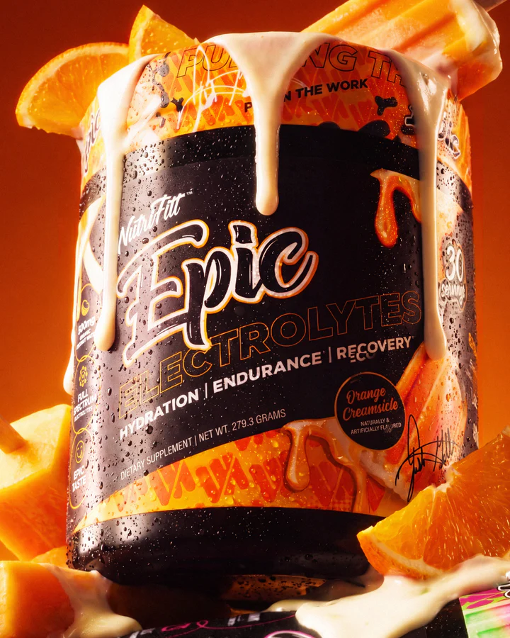 Orange Epic Electrolytes tub fills the frame beside an orange slice and melting orange-and-cream frozen pop.