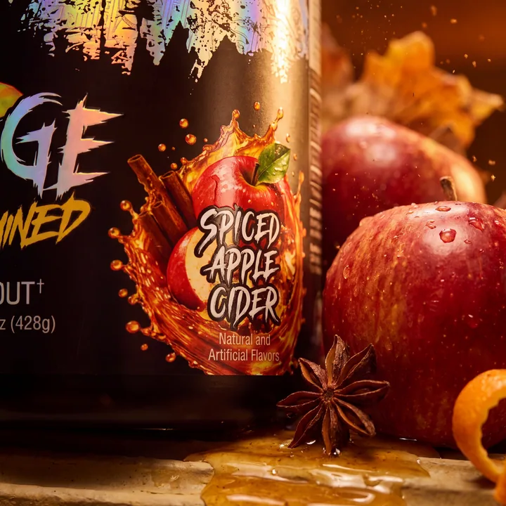 Macro view of the Spiced Apple Cider flavor badge beside a dew-covered apple, star anise and a pool of amber cider.