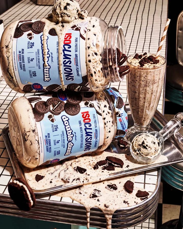ISOCLUSIONS Stacked Double Dunk tubs on a tiled diner counter surrounded by cookies and a shake.