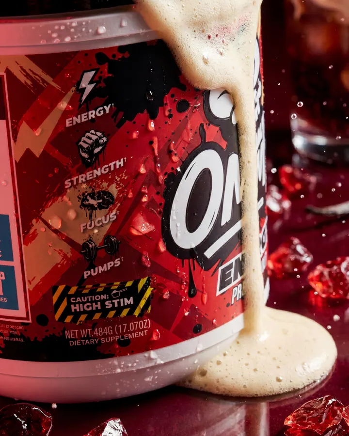 Close product view of an Ommi Energy tub covered by a ribbon of cream on a red campaign set.