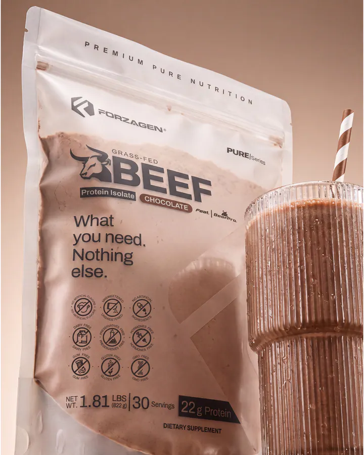 Pure Beef Chocolate protein bag beside a tall ribbed chocolate shake and striped straw.