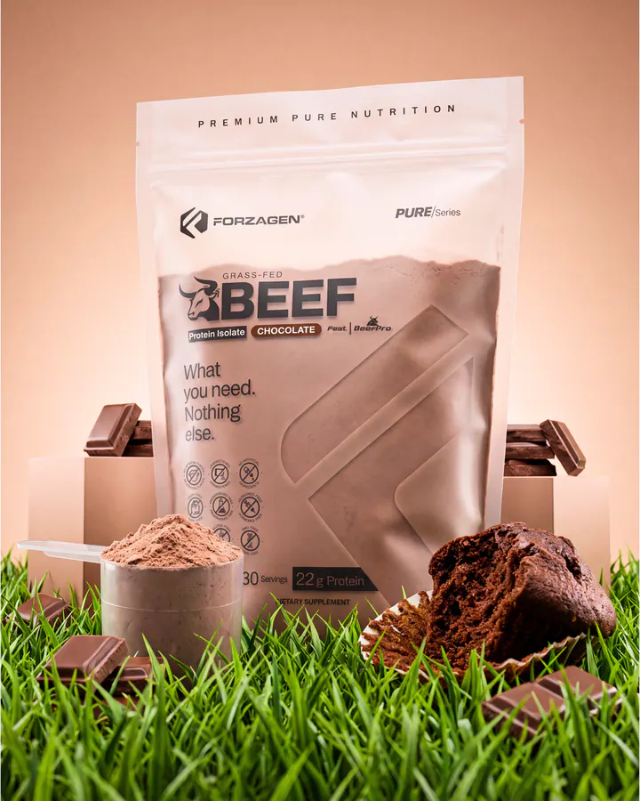 Pure Beef Chocolate protein bag with a scoop of powder, cocoa and chocolate on a grass set.