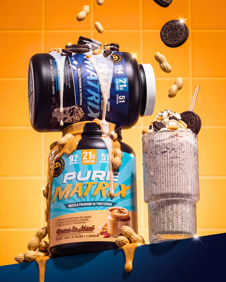 Smile Labz Pure Matrix protein tub and cookies-and-cream shake surrounded by cookies and peanuts on an orange set.