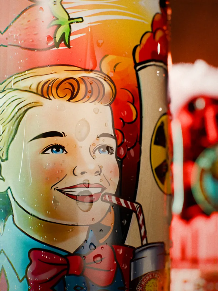 Macro of the retro illustrated boy drinking through a straw on the Reactor Red label, covered in condensation drops.